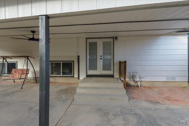 entrance to property with ceiling fan, french doors, crawl space, and visible vents