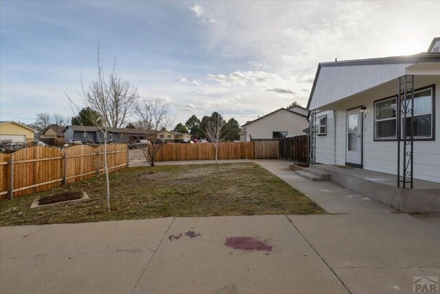 view of yard with a fenced backyard, a residential view, and a patio