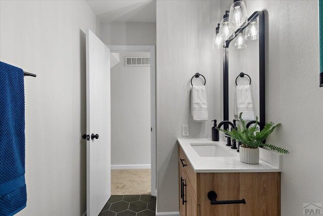 bathroom with baseboards, visible vents, and vanity