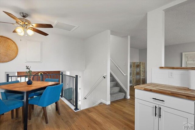 dining room featuring light wood-style floors and a textured ceiling