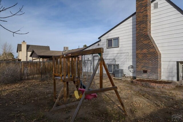 view of jungle gym with cooling unit and fence