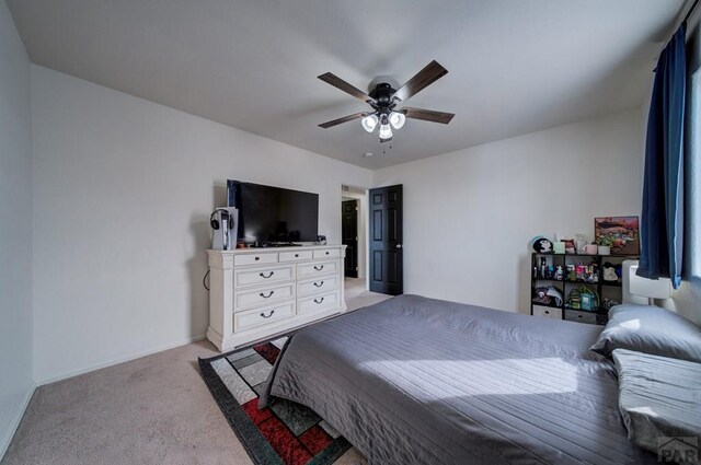 bedroom featuring baseboards, a ceiling fan, and light colored carpet