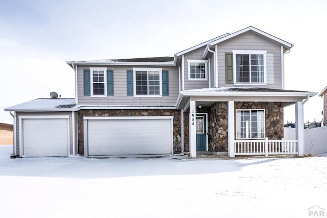 traditional-style home with stone siding, a porch, and an attached garage