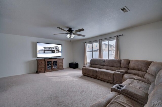 carpeted living area featuring visible vents and a ceiling fan