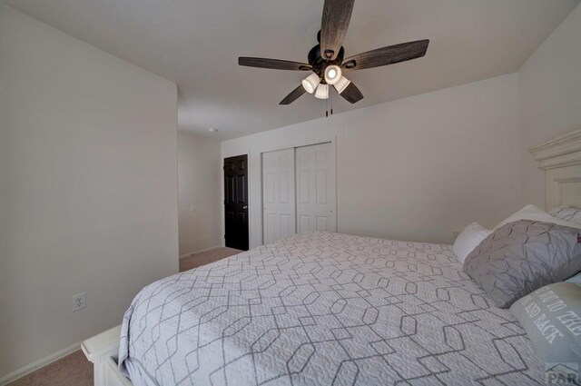 bedroom with a ceiling fan, a closet, and light carpet