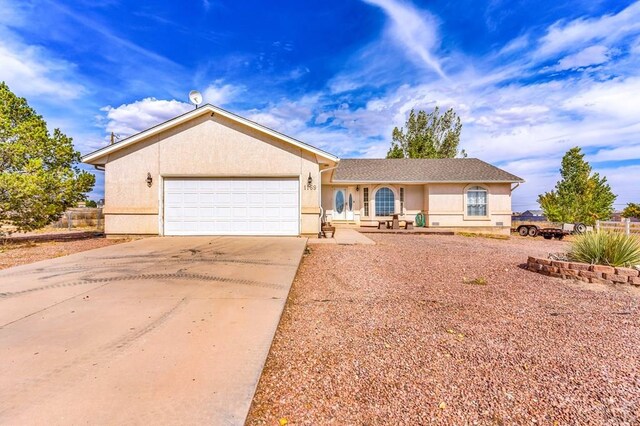 ranch-style house featuring an attached garage, concrete driveway, and stucco siding