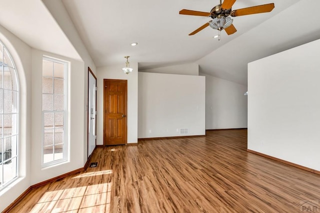 foyer entrance with lofted ceiling, wood finished floors, and a healthy amount of sunlight