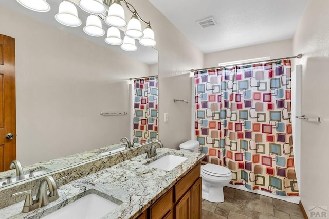 bathroom featuring toilet, curtained shower, double vanity, and a sink