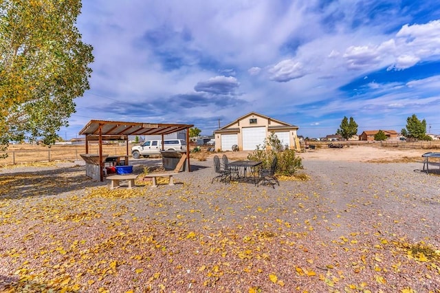 view of yard featuring a garage, fence, and an outbuilding