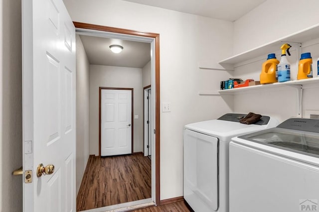 laundry room with washing machine and dryer, laundry area, baseboards, and wood finished floors