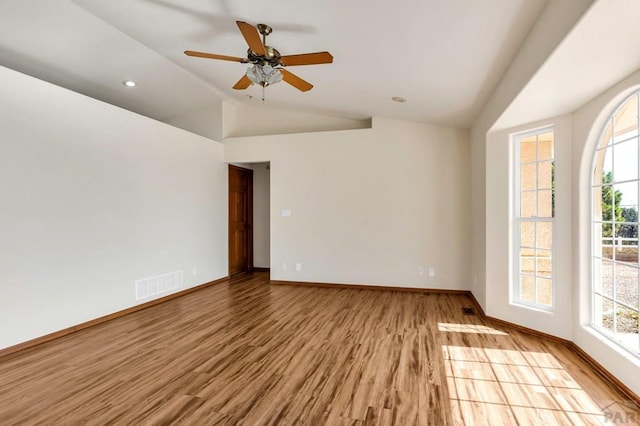 unfurnished room featuring baseboards, visible vents, lofted ceiling, wood finished floors, and recessed lighting