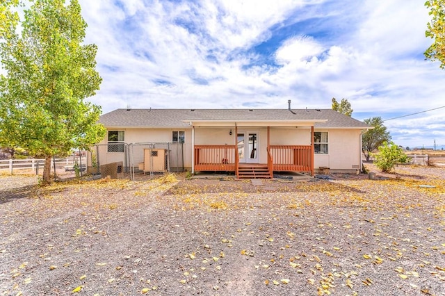 view of front facade with a gate, fence, a deck, and stucco siding