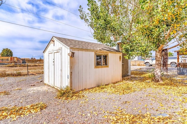 view of shed featuring fence