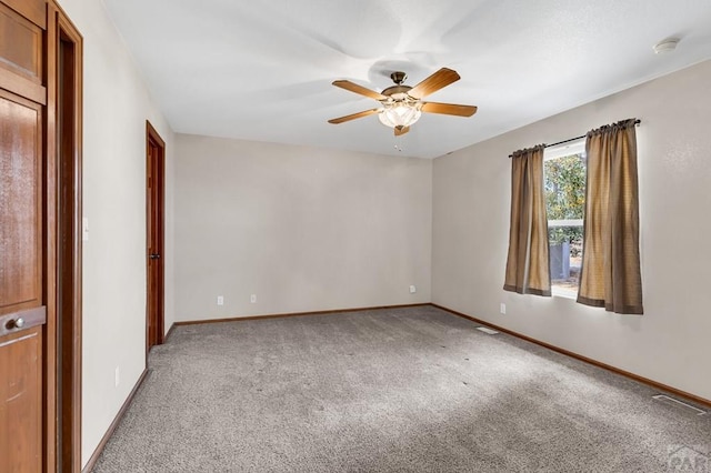 empty room featuring light colored carpet, ceiling fan, visible vents, and baseboards