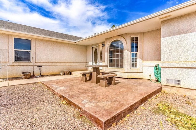 back of property with a patio area and stucco siding