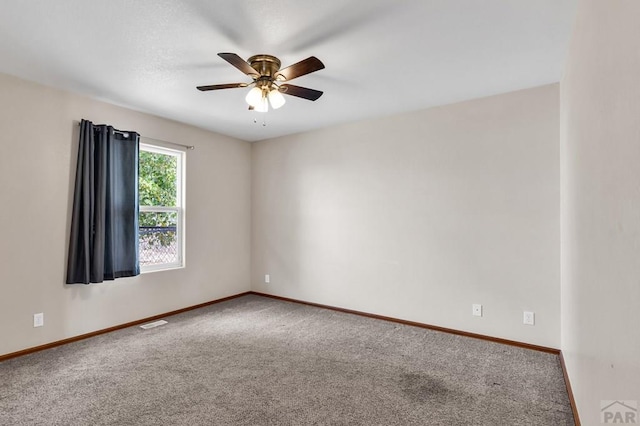 unfurnished room featuring ceiling fan, carpet floors, visible vents, and baseboards