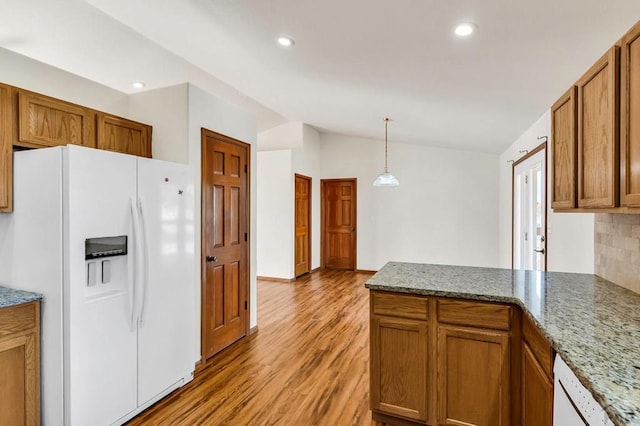 kitchen featuring hanging light fixtures, white appliances, brown cabinets, and lofted ceiling