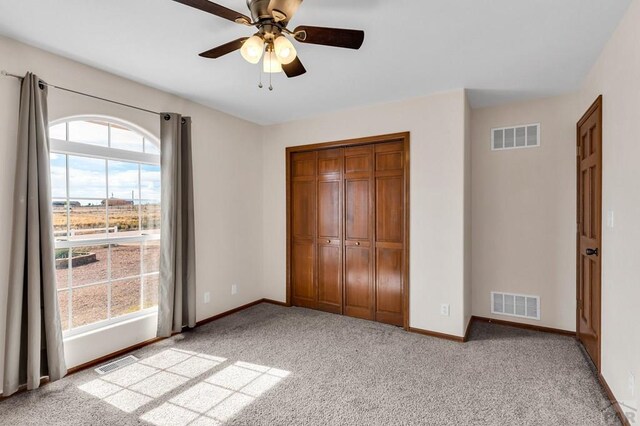 unfurnished bedroom featuring baseboards, visible vents, and light colored carpet