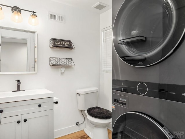 2202 W 15th St, Pueblo, CO 81003 - bathroom with stacked washer / dryer, wood finished floors, and vanity
