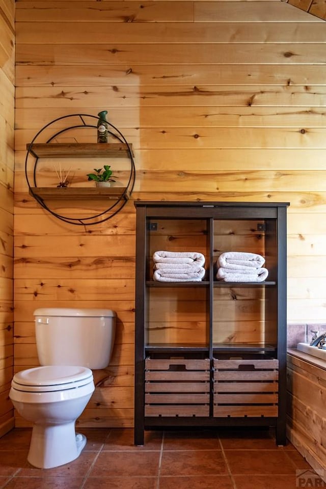 317 Parsons Rd, La Veta, CO 81055 - half bathroom featuring wood walls, tile patterned flooring, and toilet