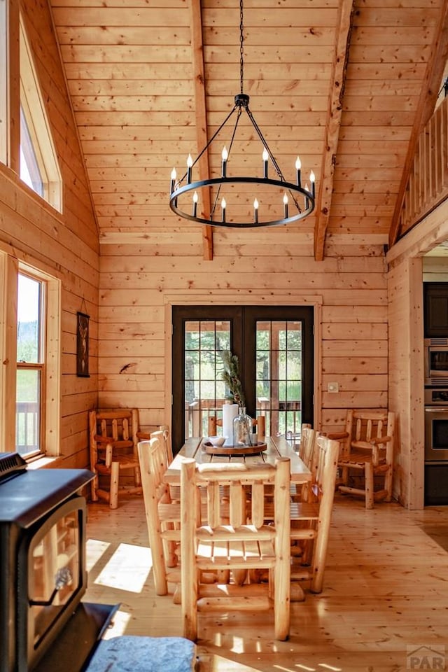 317 Parsons Rd, La Veta, CO 81055 - dining space featuring wooden walls, high vaulted ceiling, healthy amount of natural light, light wood finished floors, and a chandelier