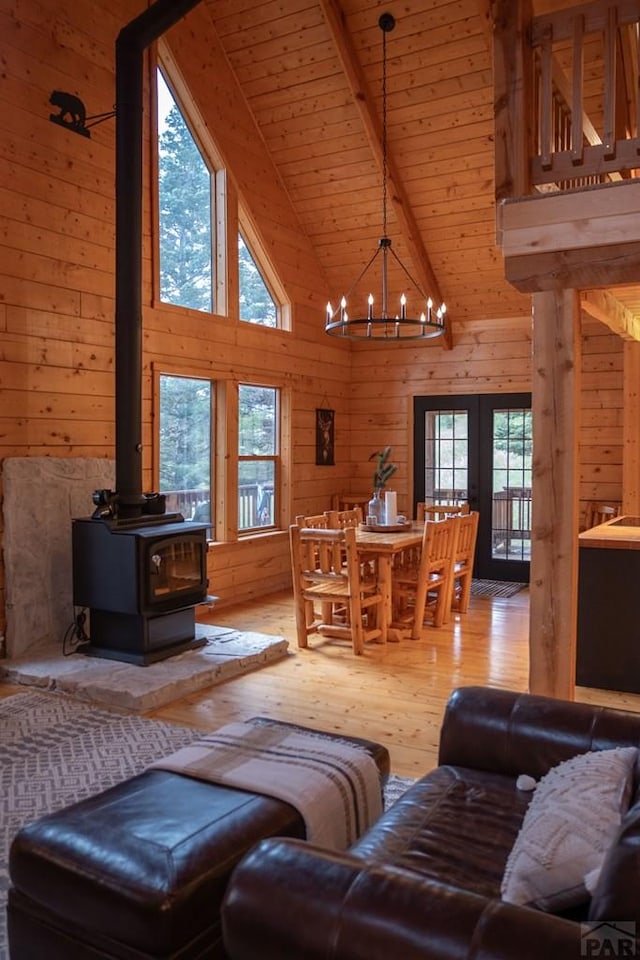 317 Parsons Rd, La Veta, CO 81055 - living area featuring wooden walls, healthy amount of natural light, light wood-style floors, a chandelier, and high vaulted ceiling