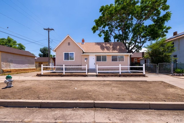 212 W Summit Ave, Pueblo, CO 81004 - view of front of home with a gate, a fenced front yard, a chimney, and stucco siding