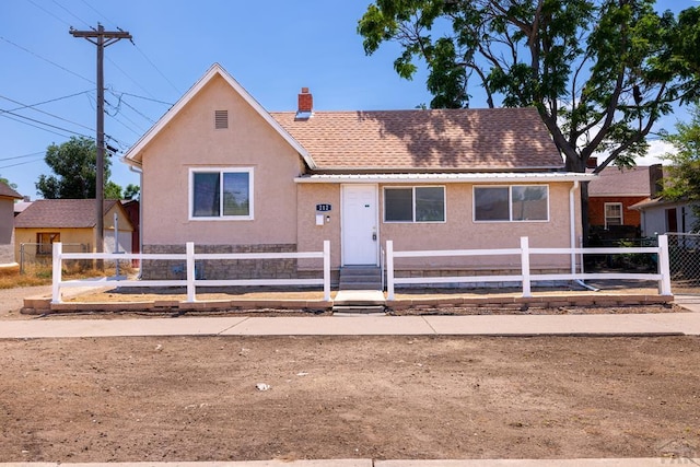 212 W Summit Ave, Pueblo, CO 81004 - view of front of home featuring a fenced front yard, a chimney, stucco siding, and roof with shingles