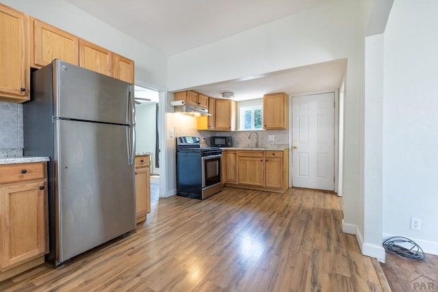 212 W Summit Ave, Pueblo, CO 81004 - kitchen with stainless steel appliances, backsplash, light wood finished floors, under cabinet range hood, and light stone countertops