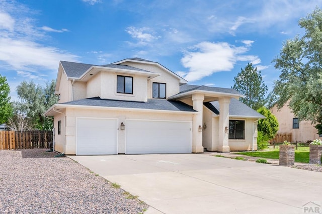 view of front of house featuring stucco siding, a shingled roof, an attached garage, fence, and driveway