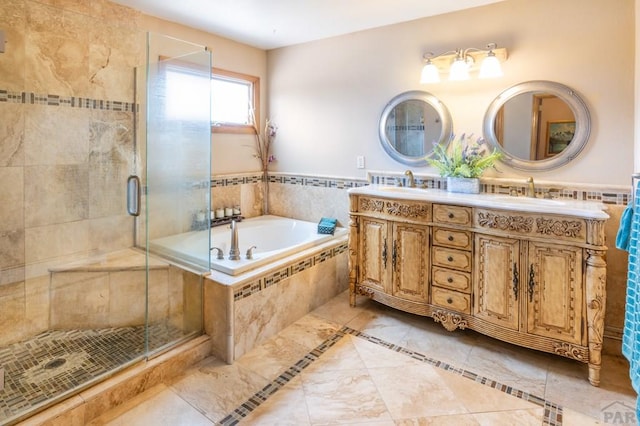 bathroom featuring a stall shower, double vanity, a sink, and a bath