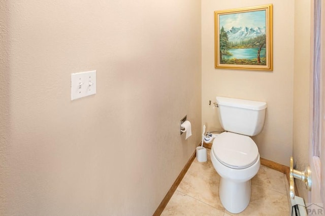 bathroom with tile patterned flooring, toilet, and baseboards