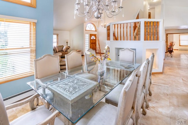 dining space featuring a chandelier, a baseboard radiator, and high vaulted ceiling