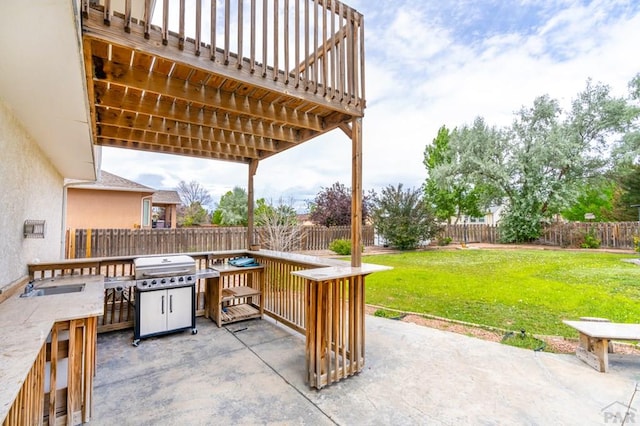 view of patio featuring a sink, grilling area, and a fenced backyard