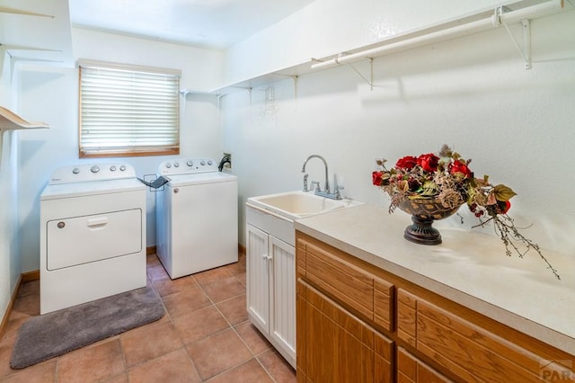 washroom featuring light tile patterned floors, cabinet space, a sink, and washing machine and clothes dryer