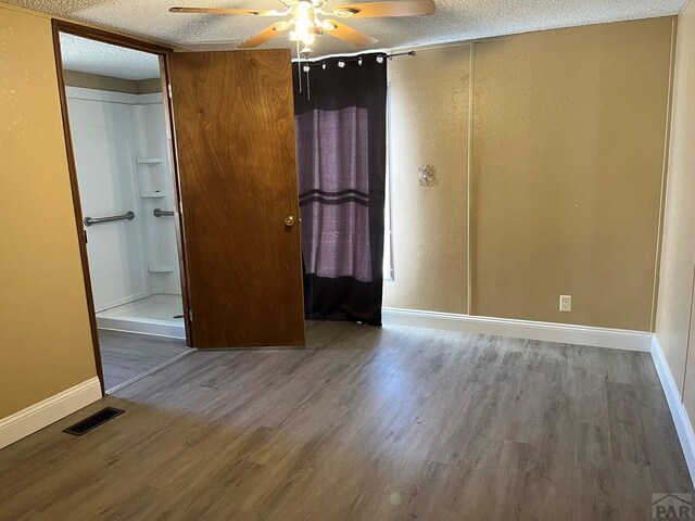 unfurnished bedroom featuring visible vents, a textured ceiling, and wood finished floors