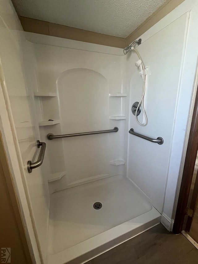 bathroom with walk in shower and a textured ceiling