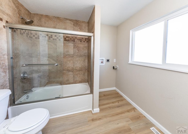 full bathroom with combined bath / shower with glass door, wood finished floors, toilet, and baseboards