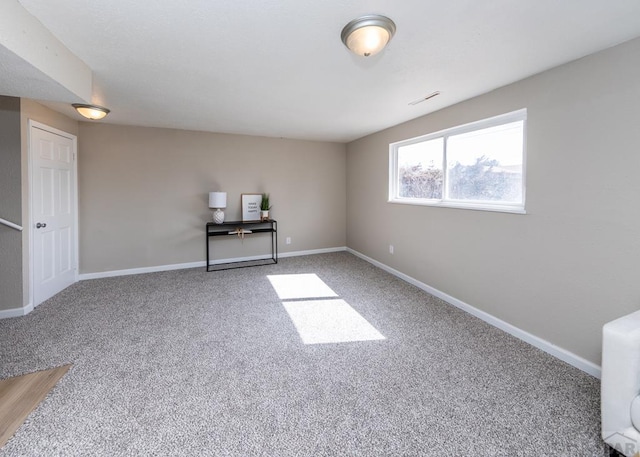 spare room featuring visible vents, baseboards, and light colored carpet