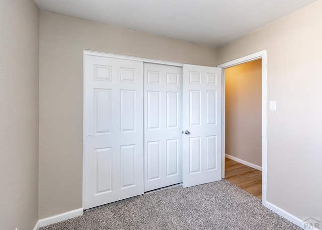 unfurnished bedroom with carpet, baseboards, and a closet