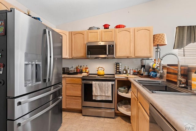 1224 Silver Hawk Ct, Pueblo, CO 81008 - kitchen with stainless steel appliances, light brown cabinets, vaulted ceiling, and light countertops