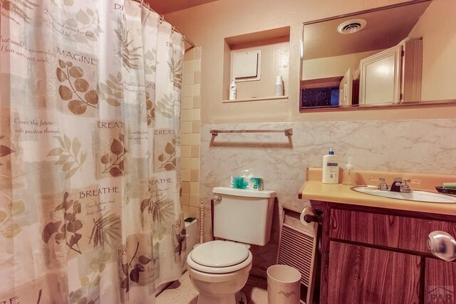 full bath featuring tile walls, curtained shower, visible vents, toilet, and vanity