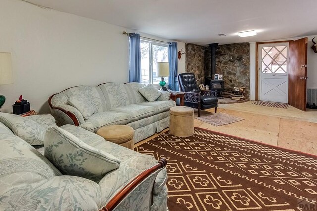 living room with a wood stove and wood finished floors