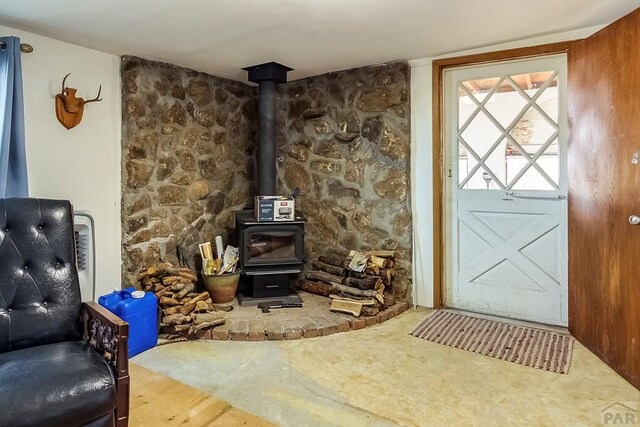 carpeted living area featuring a wood stove