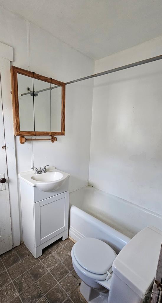 bathroom featuring toilet, tub / shower combination, and vanity