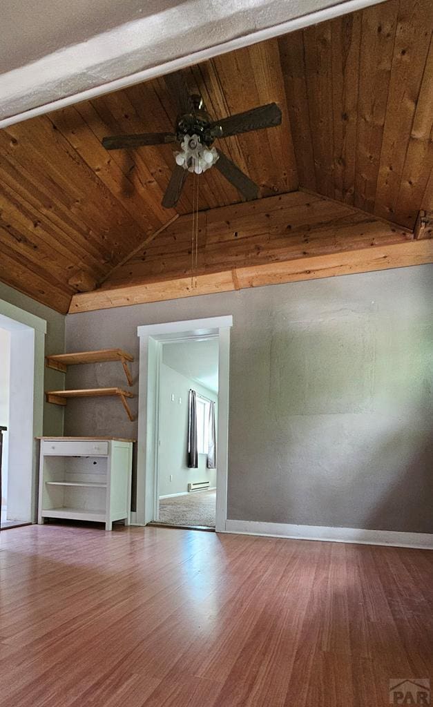 interior space with wood ceiling, vaulted ceiling, baseboards, and wood finished floors