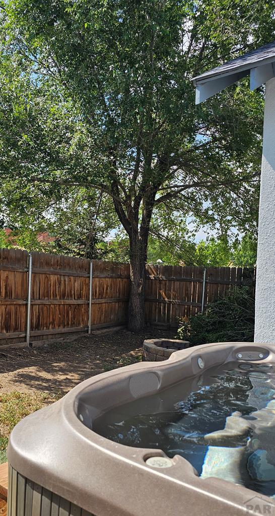 view of swimming pool featuring a fenced backyard and a hot tub