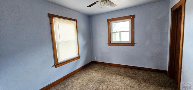 spare room with a ceiling fan, carpet, and baseboards