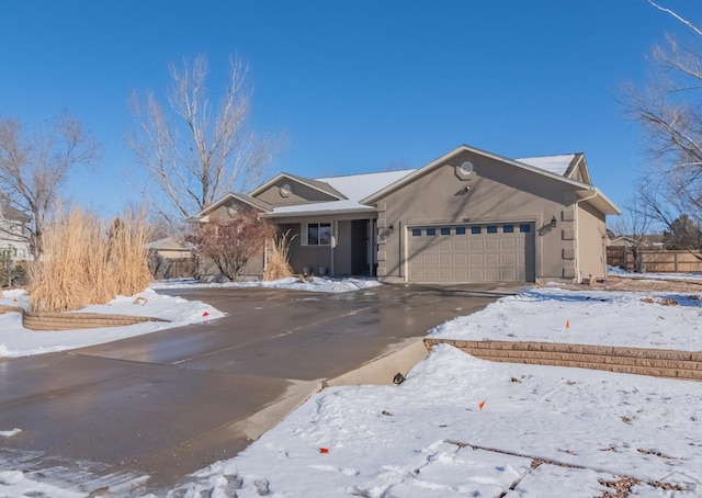 ranch-style home featuring a garage, aphalt driveway, and stucco siding