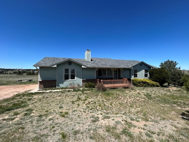 15840 Teak Pl, Elbert, CO 80106 - rear view of house featuring a lawn, brick siding, and a chimney